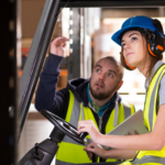 employee training colleague on forklift operations